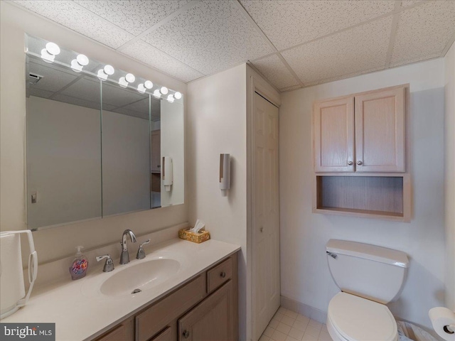 bathroom with vanity, tile patterned flooring, a paneled ceiling, and toilet