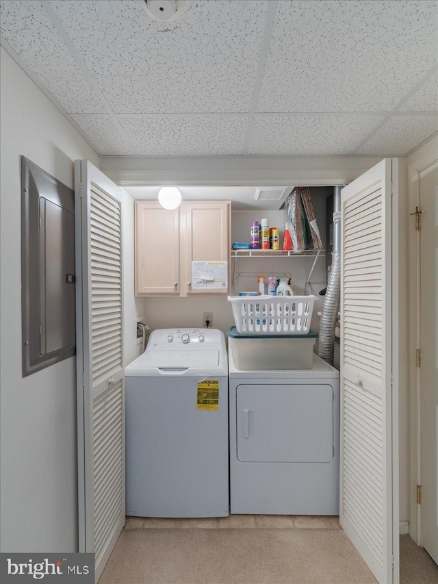 laundry room with independent washer and dryer, cabinets, and electric panel