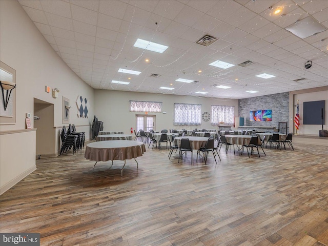 dining area featuring hardwood / wood-style flooring and a drop ceiling