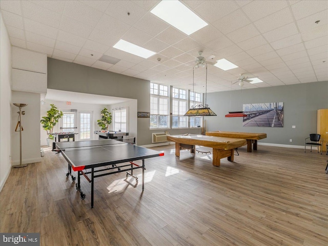 game room featuring a drop ceiling, hardwood / wood-style floors, and plenty of natural light