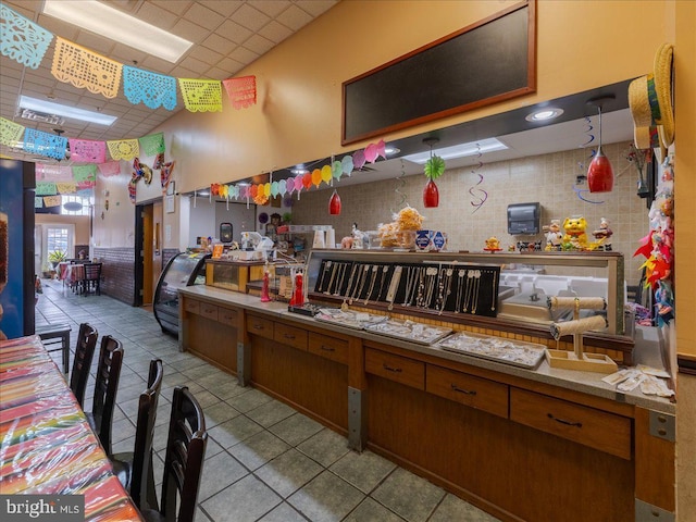 kitchen with a drop ceiling and light tile patterned floors