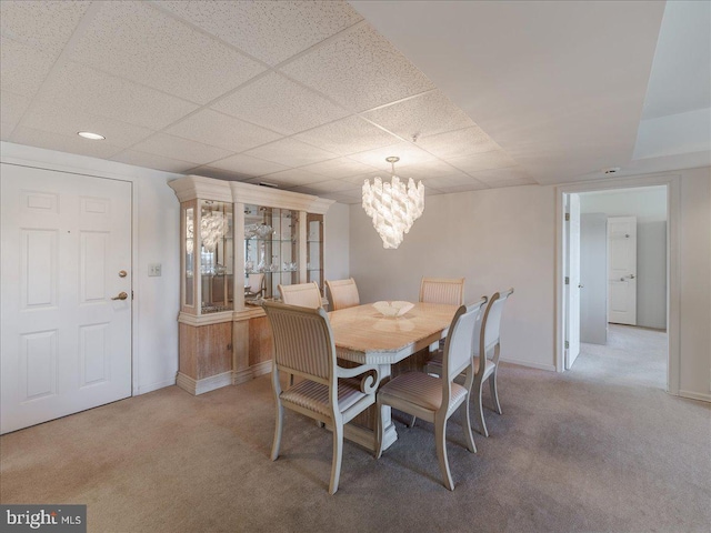 carpeted dining area featuring a paneled ceiling