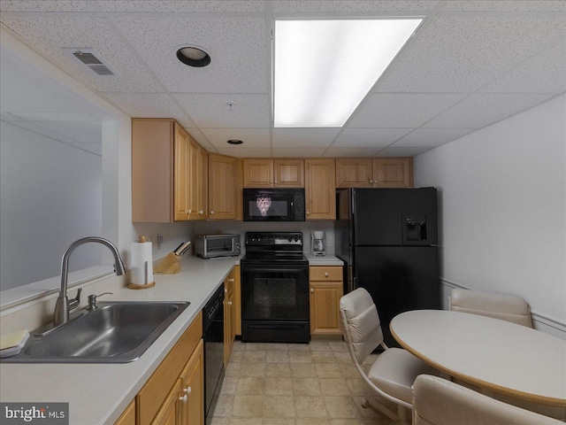 kitchen with a paneled ceiling, sink, light brown cabinets, and black appliances