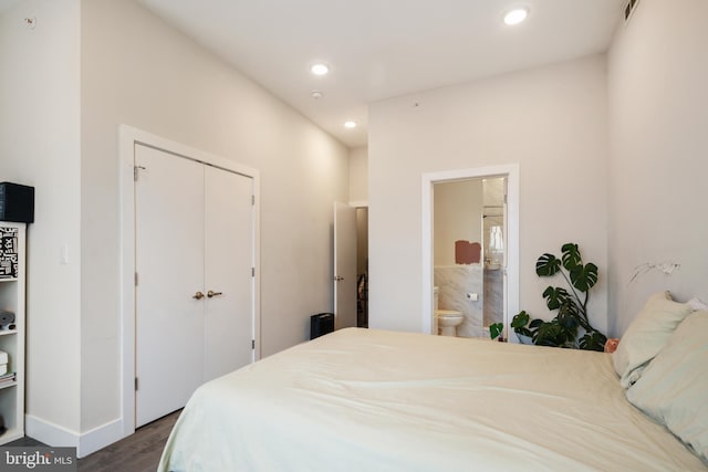 bedroom with dark hardwood / wood-style flooring, ensuite bath, and a closet