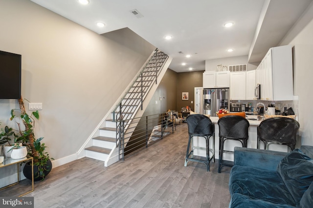 kitchen featuring open floor plan, stainless steel appliances, light wood finished floors, and visible vents