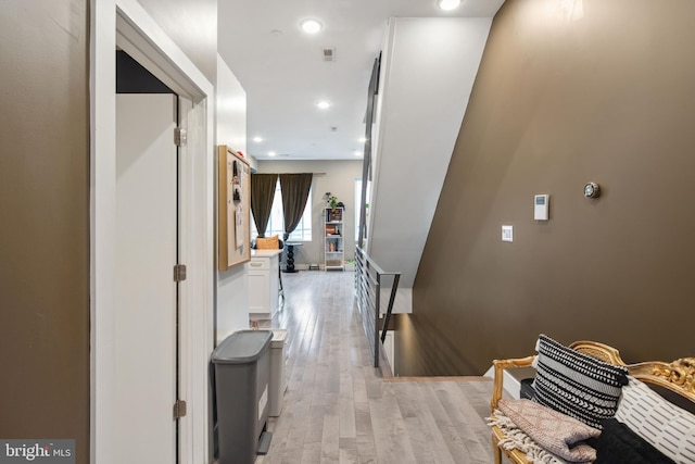 corridor featuring light wood-type flooring, an upstairs landing, and recessed lighting