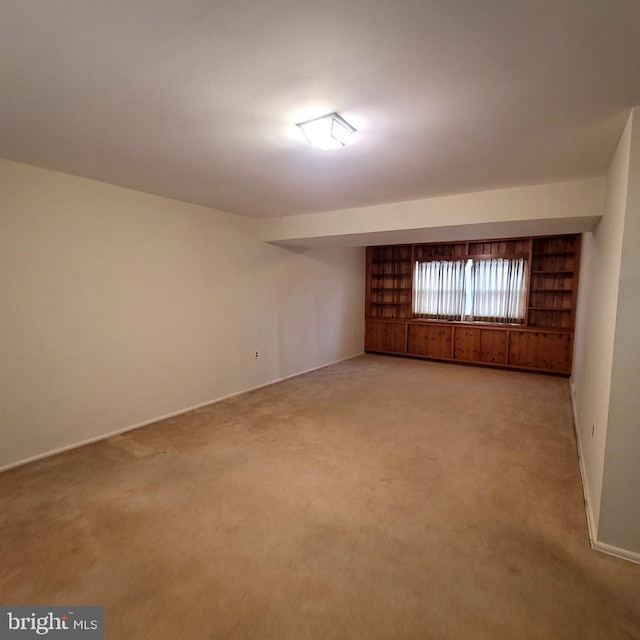 carpeted spare room featuring built in shelves