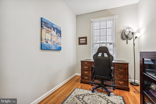 office area with light wood finished floors and baseboards