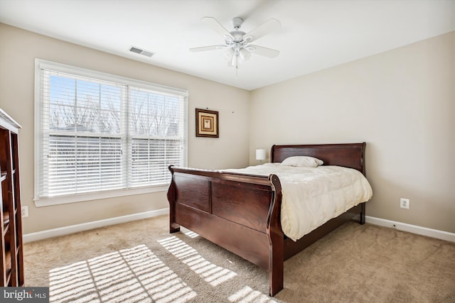 bedroom with baseboards, ceiling fan, visible vents, and light colored carpet