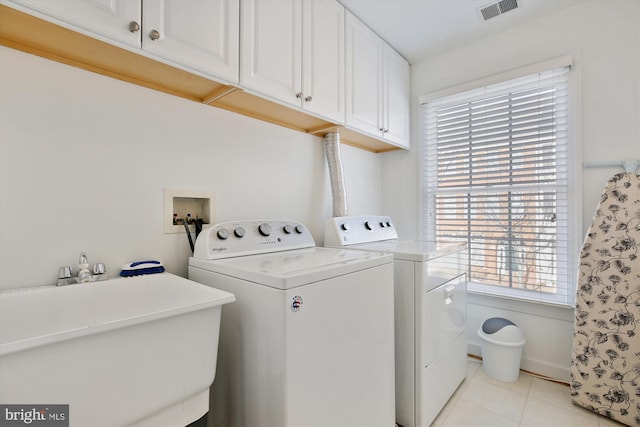 laundry room featuring light tile patterned floors, a sink, visible vents, independent washer and dryer, and cabinet space