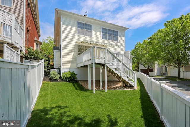 back of property featuring a fenced backyard, stairs, a wooden deck, and a yard