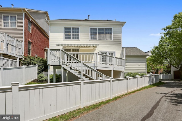 view of front of property featuring fence private yard and stairs