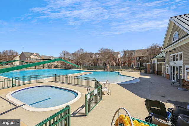 community pool with a residential view, fence, and a patio