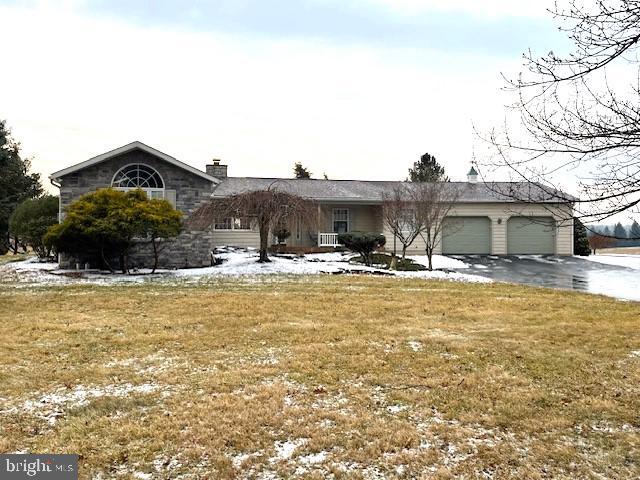 ranch-style house with a garage and a front yard