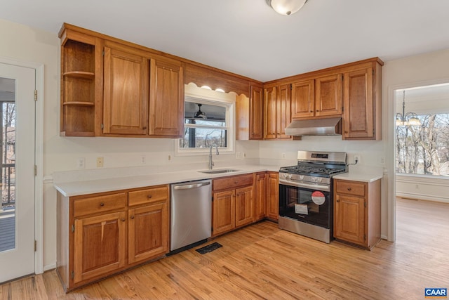 kitchen featuring an inviting chandelier, sink, stainless steel appliances, and light wood-type flooring