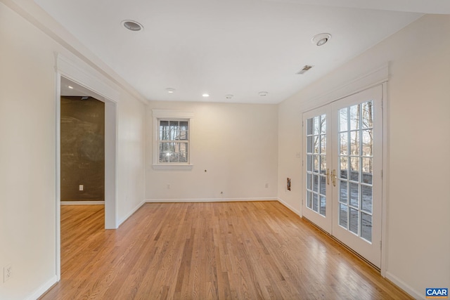 empty room featuring french doors and light wood-type flooring