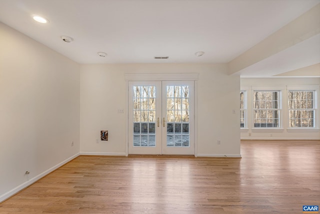 spare room with french doors and light hardwood / wood-style flooring