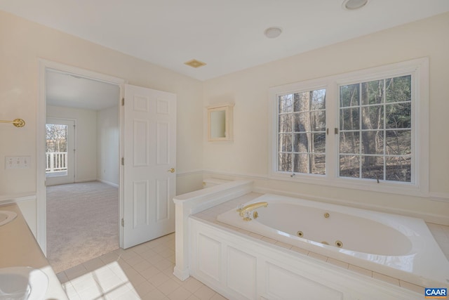 bathroom with sink, tiled bath, and tile patterned floors