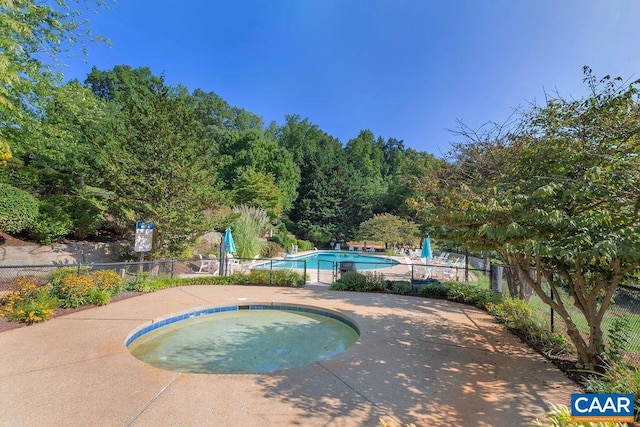 view of swimming pool with an in ground hot tub