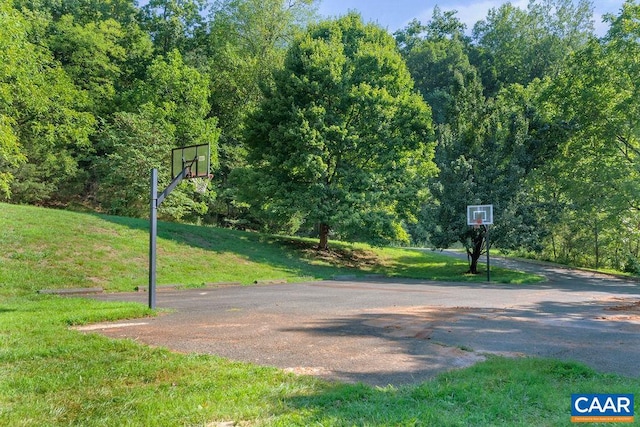 view of basketball court with a yard