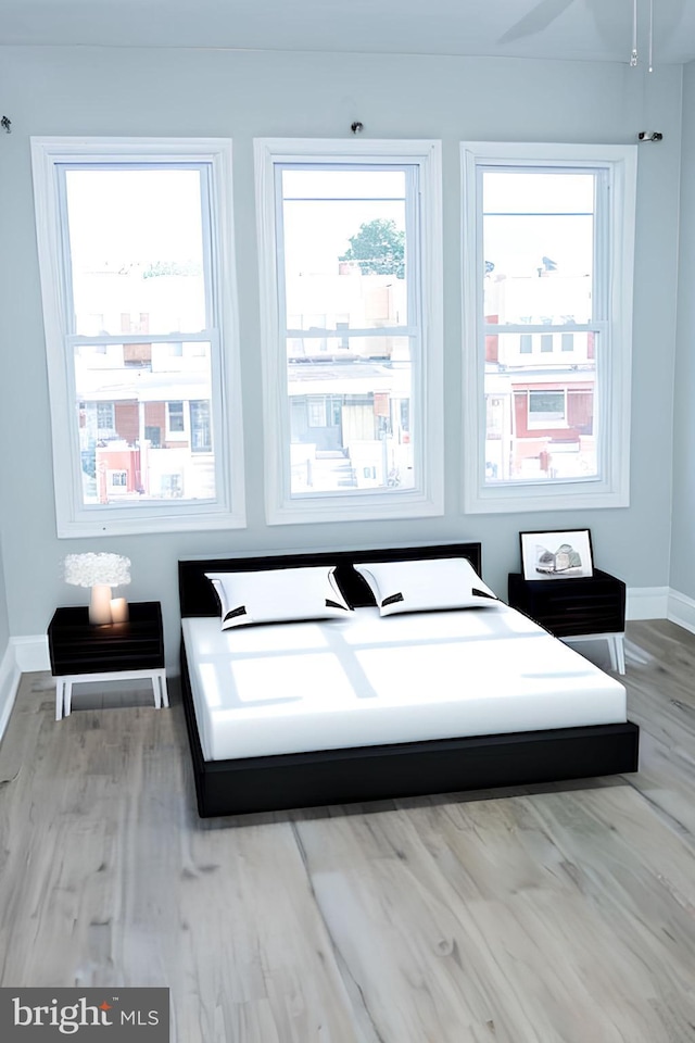 bedroom featuring multiple windows and light hardwood / wood-style floors