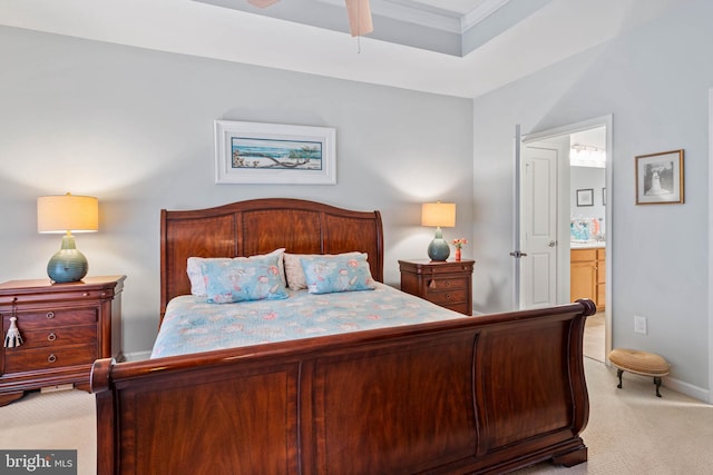 carpeted bedroom featuring ornamental molding and ensuite bathroom