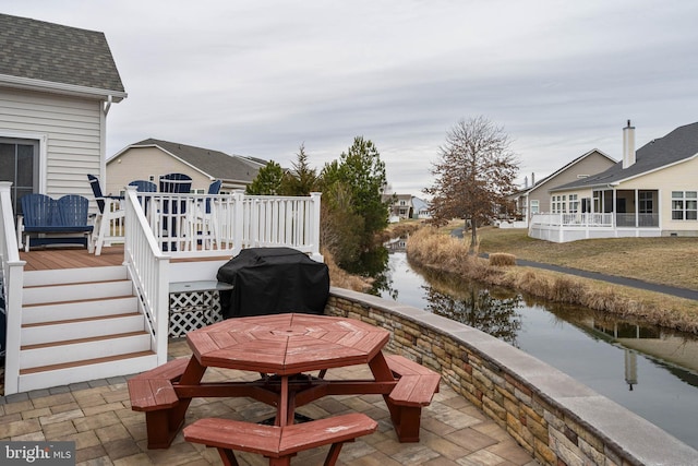 view of patio / terrace featuring a deck with water view and a grill