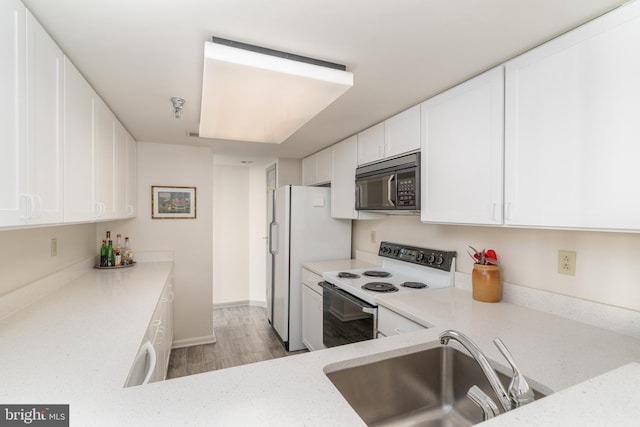 kitchen featuring white cabinetry, sink, white appliances, and light wood-type flooring