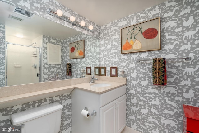 bathroom featuring toilet, vanity, and walk in shower