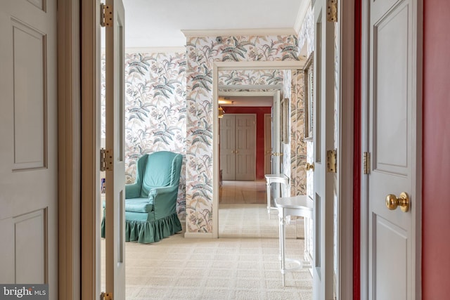 hallway featuring ornamental molding and light colored carpet