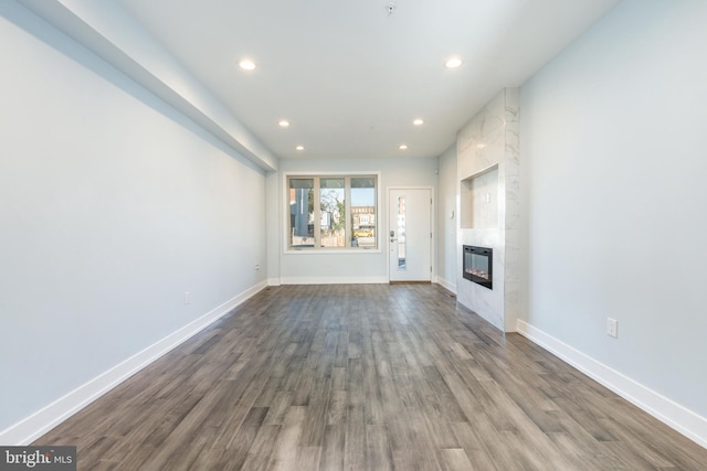 unfurnished living room featuring a fireplace and dark hardwood / wood-style flooring