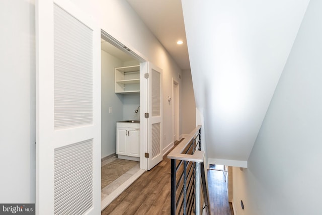 stairs featuring hardwood / wood-style flooring and sink