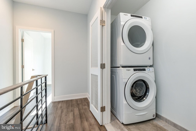 washroom featuring stacked washer and clothes dryer and hardwood / wood-style floors