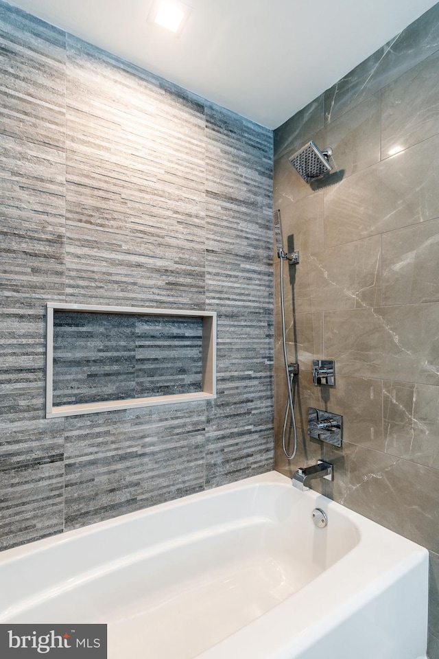 bathroom featuring tiled shower / bath