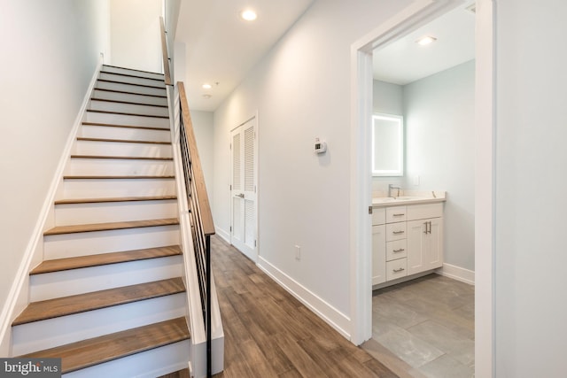 staircase featuring hardwood / wood-style flooring and sink