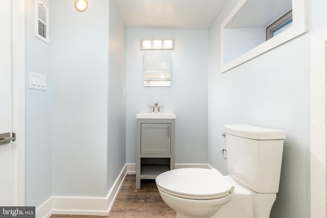 bathroom featuring vanity, hardwood / wood-style floors, and toilet