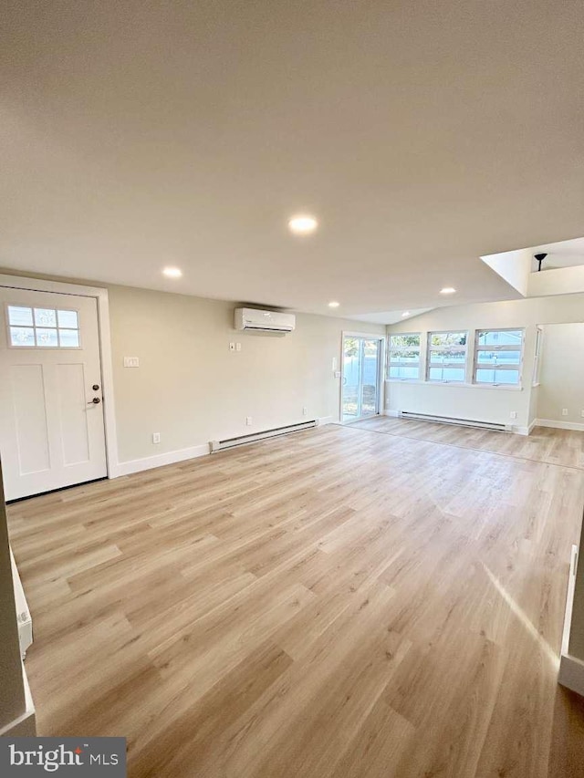 unfurnished living room with baseboard heating, light hardwood / wood-style floors, and a wall unit AC