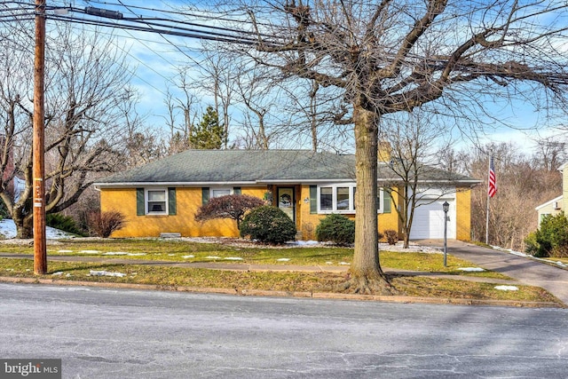 ranch-style house with a garage and a front yard