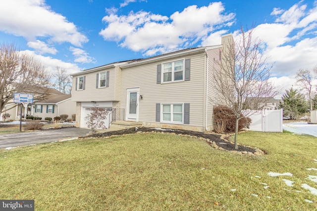 bi-level home with a garage and a front lawn