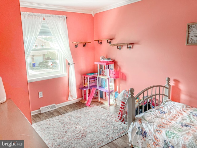 bedroom featuring hardwood / wood-style flooring and crown molding