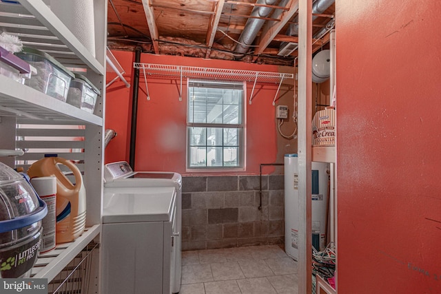 laundry room with washing machine and clothes dryer, tile patterned flooring, and water heater