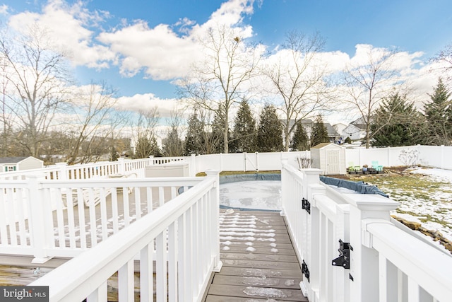 snow covered deck with a storage shed