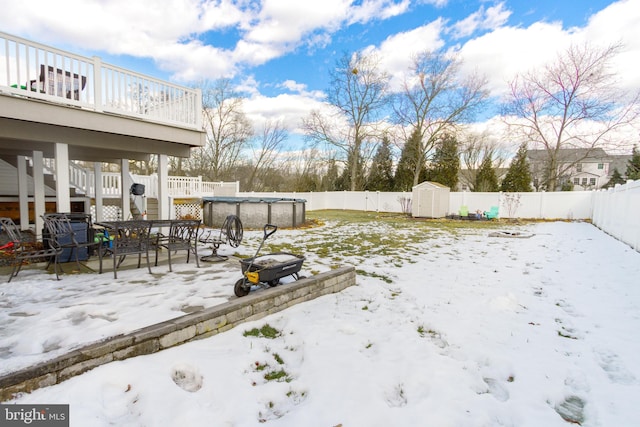 yard covered in snow featuring a storage unit and a fenced in pool