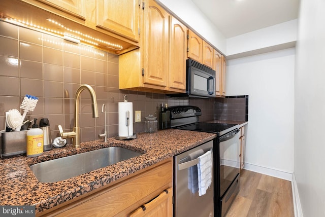 kitchen featuring sink, tasteful backsplash, black appliances, dark stone counters, and light brown cabinets