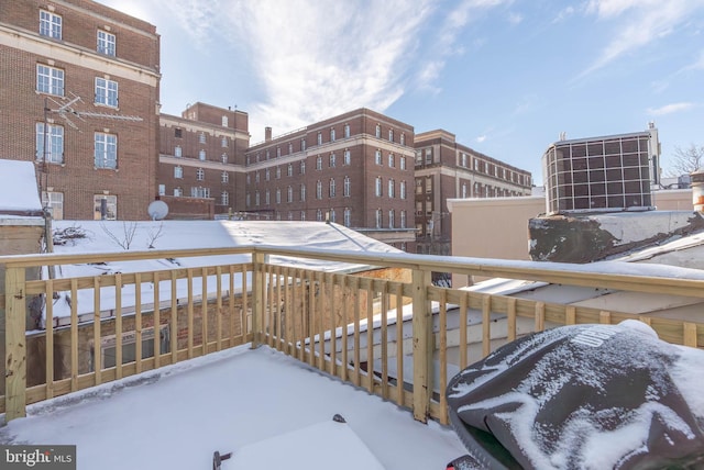 snow covered back of property with central AC