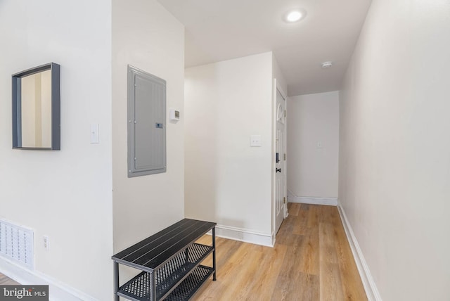 hall featuring electric panel and light hardwood / wood-style flooring