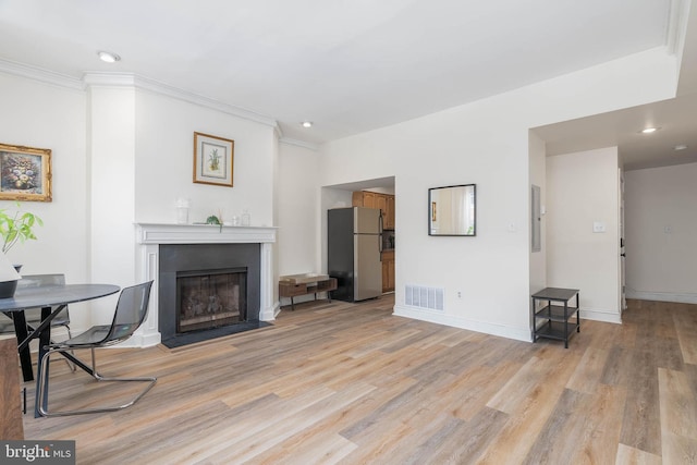 living room with light hardwood / wood-style flooring and ornamental molding