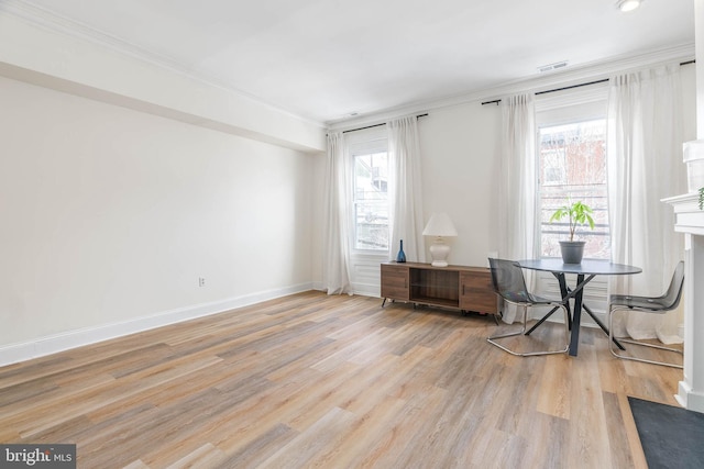 unfurnished room featuring ornamental molding, light hardwood / wood-style flooring, and a wealth of natural light