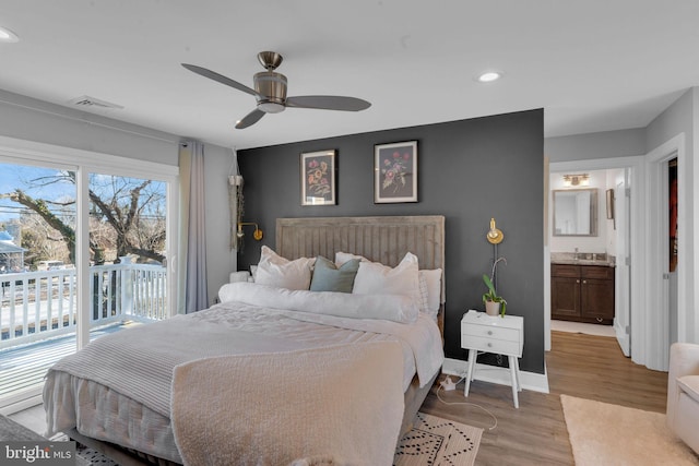 bedroom featuring access to exterior, ensuite bath, light hardwood / wood-style flooring, and ceiling fan