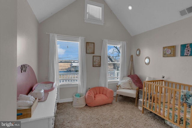 carpeted bedroom with a crib and high vaulted ceiling